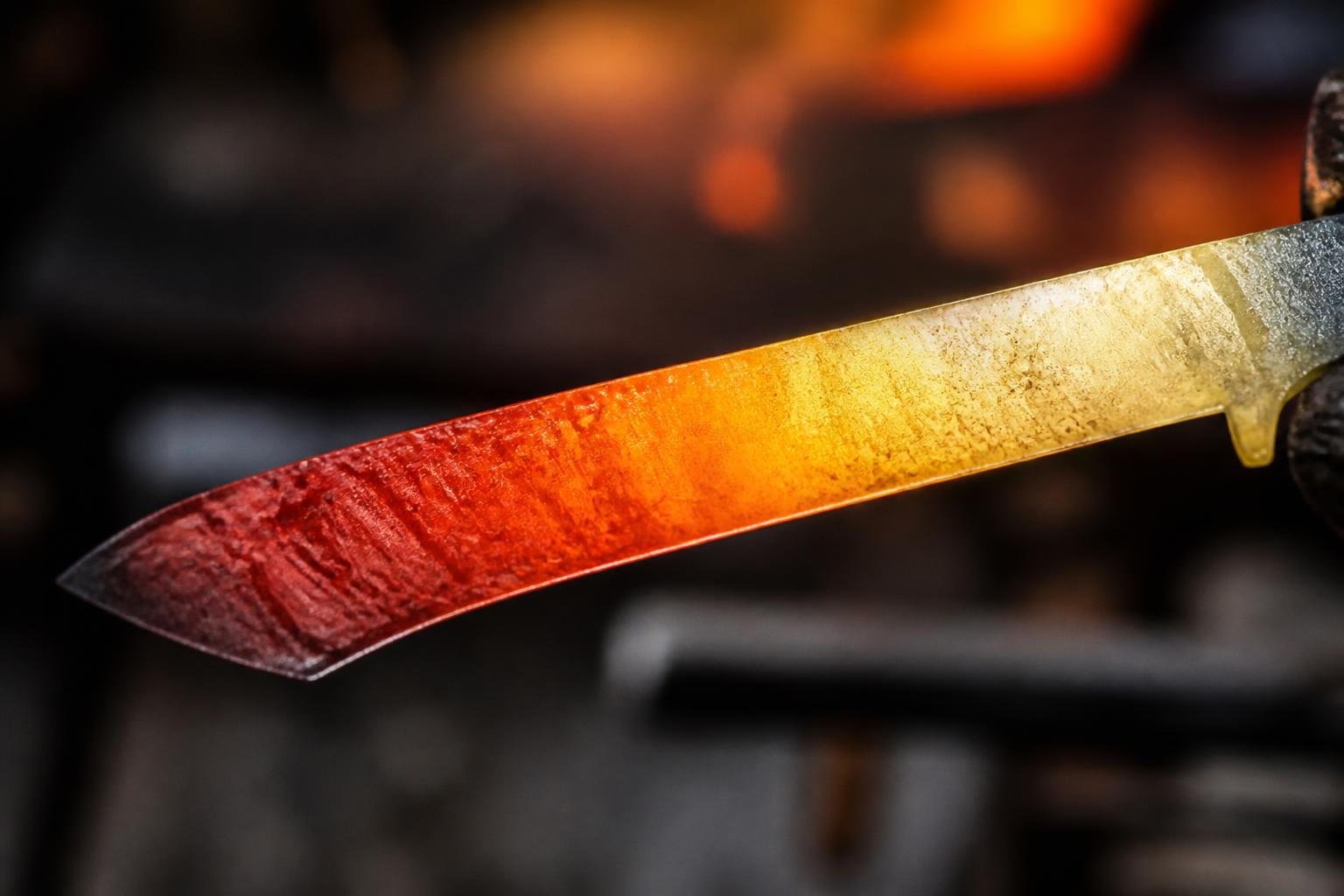 Lame d'acier aux teintes de revenu : du rouge au doré, représentant les différentes températures